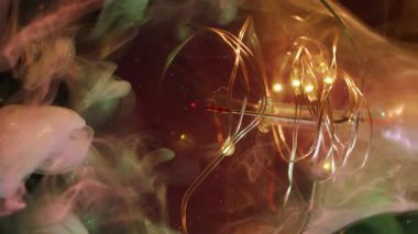 Bulanık parıltı akışı. Ampul gecesi. Işıldayan yeşil gri leke boyası. Çelenk siyah soyut arkaplan üzerinde renk parçacıkları girdap.