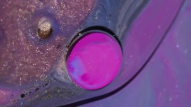 Parlak mürekkep akışı. Parıldayan baloncuklar. Odaklanmamış pembe turuncu renkli damlacık simli akrilik yağ suyu soyut sanat arka planında yüzüyor..