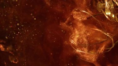Köpüklü sıvı. Odaklanmış çelenk aydınlatması. Turuncu duman rengi mürekkep akışı. Bulut patlaması parçacıkları çarpar bokeh ampulü soyut siyah arkaplan.