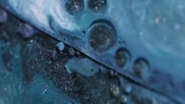 Parlak yağ mürekkebi. Arkaplanı boya. Odaklanmamış mavi renkli mermer parıltılı su kabarcıkları sabunlu dokunun etrafında akrilik sanat soyutlaması üzerine akıyor..