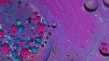 Parlak mürekkep. Boya dalgası. Odaklanmamış pembe mavi damlacık parıltılı yağ akrilik kabarcıklar soyut sanat arka planında yüzen sıvı.