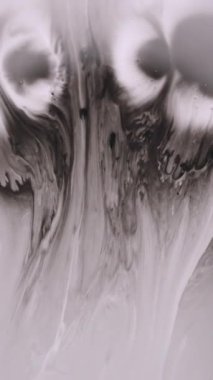 Dikey video. Akan mürekkep. Damla damla. Odaklanmamış siyah beyaz lekeler soyut yaratıcı sanat arka planında lekeler..