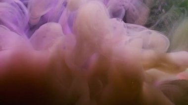 Parıldayan mürekkep dokusu. Atmosferik duman. Soyut arkaplanda yüzen kimyasal ışıltılı suda bulanık pembe sarı bulut boyası..