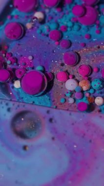 Dikey video. Yağ damlası. Sıvı arka plan. Mermer su yuvarlak desenli mor pembe mürekkep yaratıcı sanat soyutlamasına akıyor..