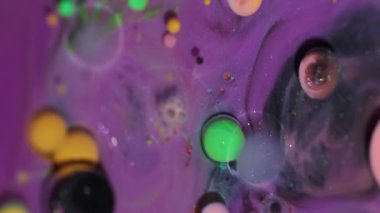 Parlak yağ mürekkebi. Arkaplanı boya. Bulanık mor yeşil renk parıltılı su kabarcıkları sabunlu dokunun etrafında akrilik sanat soyutlamasında akıyor..