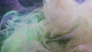 Su altı mürekkebi sıçraması. Boya akışı. Soyut arkaplana yayılan pembe mor renkli gökkuşağı simli duman..