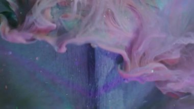 Shimmering drip. Blurred fluid blend. Pink liquid spill on art cube. Turquoise color pigment particles underwater dissolving abstract background.