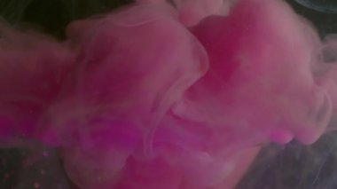 Pembe sis sıçraması. Buhar dokusu. Odaklanmamış parlak mor neon rengi mürekkep kırık ampul soyut koyu siyah buhar bokeh arkaplan üzerinde girdap.