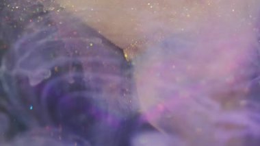 Işıldayan sanat bulutu. Görüntü pırıl pırıl akıyor. Küp üzerinde renkli akrilik mürekkep damlası karışımı. Haze parçacıkları mor beyaz gökkuşağı sıvısı soyut arkaplan.