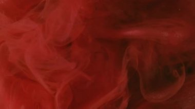 Buhar mürekkebi. Renkli su. Odaklanmamış pembe turuncu parıltılı girdap dalgalanan kimyasal alev soyut karanlık kara sanat soyutlaması üzerine yayılıyor..