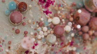 Boya baloncukları. Sıvı arka plan. Bokeh sanatının soyutlamasında parlak dokular akan parlak suda bulanık mavi pembe mürekkep..