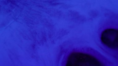 Yüzen mürekkep. Arkaplanı boya. Yaratıcı soyutlama üzerine yayılan mavi renkli su dokusu parlak sıvı koyu siyah lekeler akıtıyor.