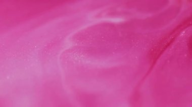 Parlak mürekkep. Parlak parçacıklar. Soyut sanat eserlerinin arka planında sönük pembe renkli parıltılı su ıslak kimyasal boya yüzüyor..