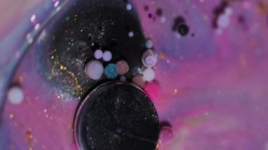 Akrilik ışıltılı doku. Yağ kabarcıkları. Bulanık sarı mor renk, parlak parlak yuvarlak mürekkep, parlak su sıvısı soyut sanat arka planında yüzüyor..