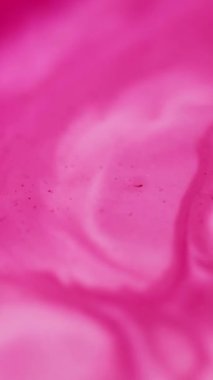 Dikey video. Mürekkep döküldü. Akrilik pigment. Odaklanamayan pembe lekeler soyut arka planda renk kimyasal akışı yayıyor.