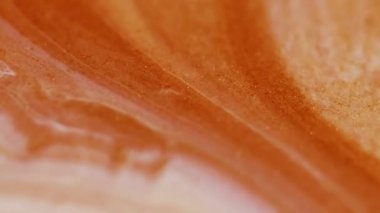 Renk sıvısı. Parıltı karışımı. Su taneleri dokusunda çözünmüş turuncu bronz pigment soyut sanat arka planında yüzen mermer dokusu sıvısı.