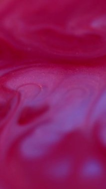 Dikey video. Dalga mürekkebi. Enamel sıvısı. Bulanık kırmızı neon akarsu sıvı kırmızı lekeler soyut sanat akrilik arka planda yayılıyor..