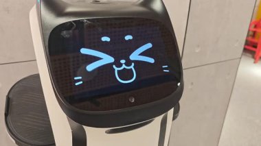 Gelecekçi hizmet robotu kedisinden esinlenilmiş ekranda çeşitli dijital ifadeler sergiliyor. Bu otonom robot son teknoloji müşteri hizmetleri sunuyor