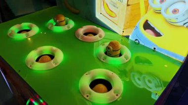 Genç oyuncu, yanan ışıklarla bir Köstebek 'e çarpan renkli bir atari salonunda basit bir çekiç kullanarak çizgi film yaratıklarını haklıyor. Tiflis, Gürcistan - 17 Kasım 2025.