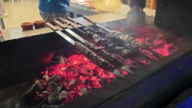 Et şişleri kızgın kömürlerin üzerinde cızırdıyor, geceyi baştan çıkarıcı dumanlı bir kokuyla dolduruyor. Bu nefis sokak yemekleri akşam gökyüzünün altında mükemmel bir şekilde pişiriliyor.