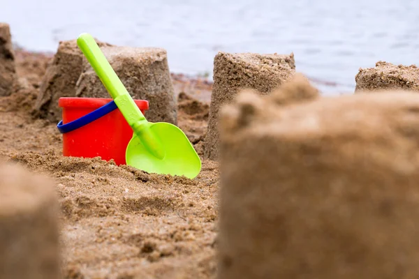 Sandslott med sand leksaker på vatten — Stockfoto