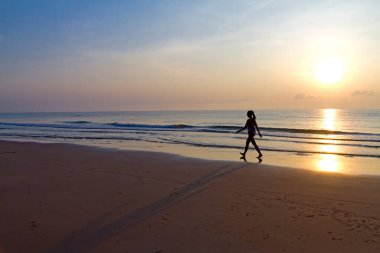 Kumsalda yürüyen gündoğumu olan kadınlar Bang Boet, Tayland 'ın Khiri Khan Eyaleti' nde seyahat ve dinlenme ile ünlüdür..