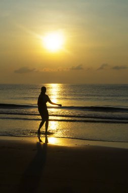 Tayland 'ın Prachuap Khiri Khan Eyaleti' nde kumsalda gündoğumu ve siluet ile egzersiz yapan kadınlar seyahat ve dinlenme ile ünlüdür..