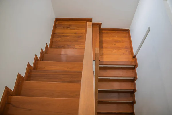 Staircase, wooden floor and black iron rail.