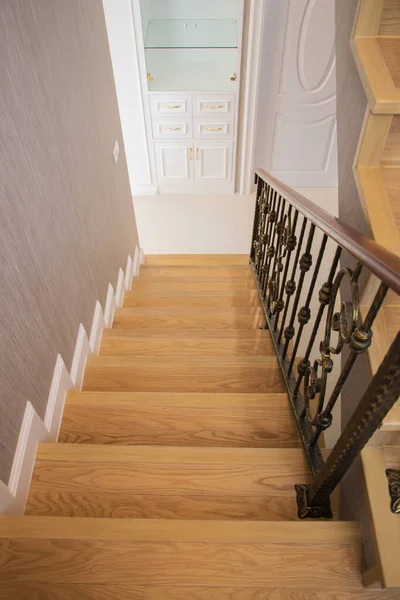 Staircase, wooden floor and black iron rail.