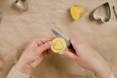 Kalp şeklinde bir patates pulu. Sevgililer Günü için bir hediye süsleme süreci. 14 Şubat 'taki kutlamaya hazırlanıyorum..