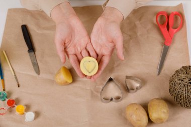 Kalp şeklinde bir patates pulu. Sevgililer Günü için bir hediye süsleme süreci. 14 Şubat 'taki kutlamaya hazırlanıyorum..
