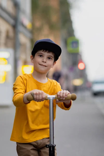 Kluk se skútrem. Šťastná jízda po městě — Stock fotografie