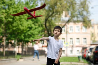 Şehirde oyuncak uçağı olan bir çocuk..