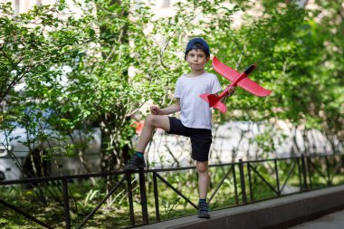 Şehirde oyuncak uçağı olan bir çocuk..
