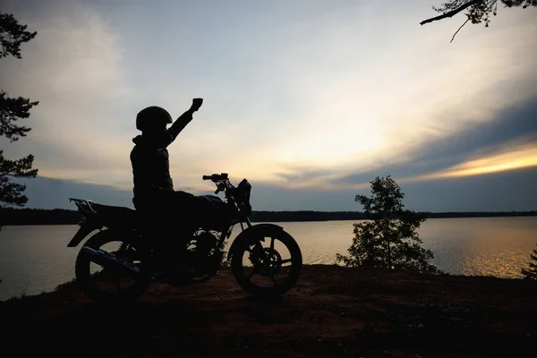 Silhouette eines Mädchens auf einem Motorrad bei Sonnenuntergang — Stockfoto