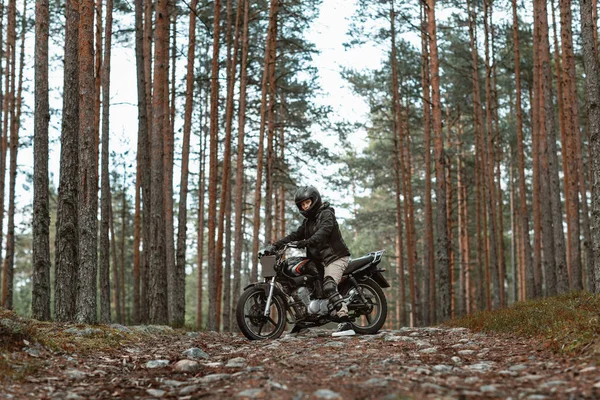 Жінка на мотоциклі в природі. мотоцикліст прогулюється лісом Стокова Картинка