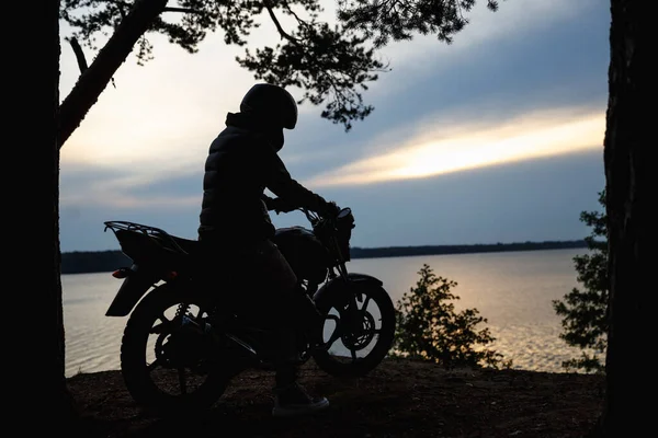 Sylwetka dziewczyny na motocyklu o zachodzie słońca — Zdjęcie stockowe