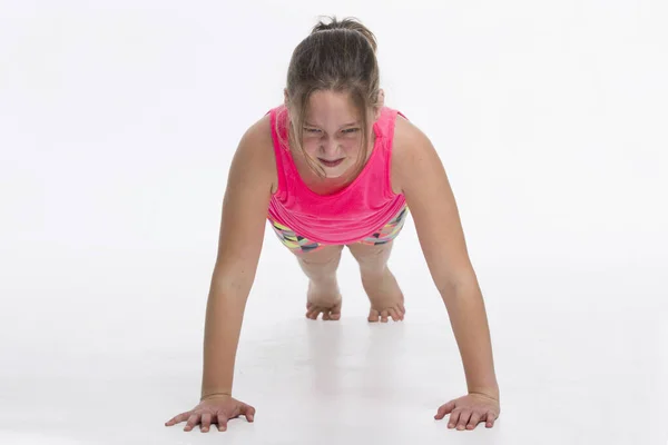 Uma Jovem Garota Tween Fazendo Flexões Com Uma Expressão Determinada — Fotografia de Stock