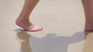 Kadın okyanus suyunda ağır çekim 120 fps yürür.