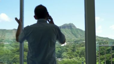 İş adamı telefonda konuşuyor ve Hawaii 'de 4K' da başarılı bir anlaşma yapıyor.