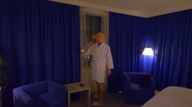 Domuz maskeli bir adam işten sonra rahatlıyor ve viski içiyor. 4K ağır çekim 60fps.