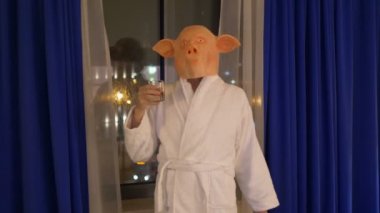Domuz maskeli bir adam işten sonra rahatlıyor ve viski içiyor. 4K ağır çekim 60fps.