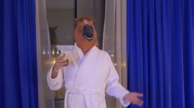 At maskeli bir adam işten sonra 4K ağır çekim 60fps ile rahatlıyor ve viski içiyor.