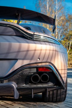 Spoiler ve birden fazla egzoz borusuyla pahalı bir spor arabasının arka çekimi.