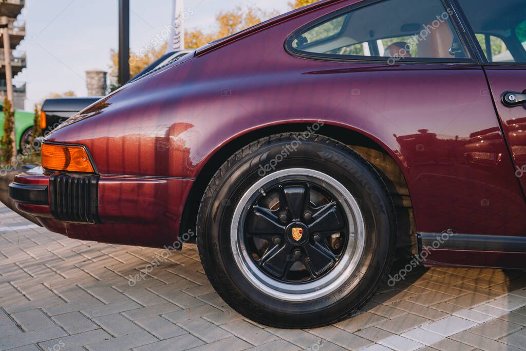 Vilnius, Lithuania - 2025-09-20 - Close-up of rear wheel with gold logo of Porsche and fender on classic Porsche 911 S