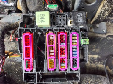 Sudan zarar görmüş bir aracın içinde kumla kaplı oksitlenmiş sigorta bloğu.