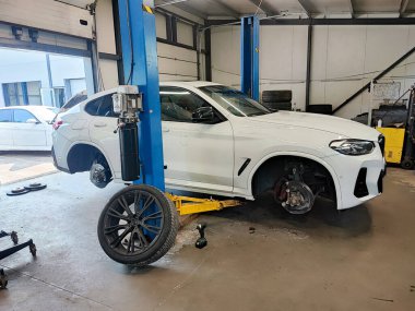 Tekerleksiz beyaz modern SUV tamir sırasında kaldırıldı.