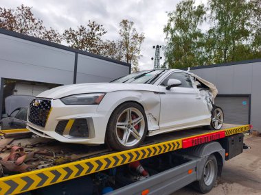 Vilnius, Litvanya - 2025-10-06 - Otomobil servisi yakınlarındaki bir karavanda kaza üstüne araç taşıma servisi