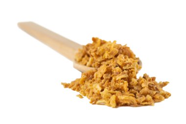 Beyaz arka planda izole edilmiş ahşap kaşıkta kızartılmış soğan taneleri. Baharatlar ve yemek malzemeleri..