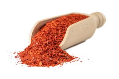 Beyaz arka planda izole edilmiş ahşap kepçe içindeki çekirdeksiz kırmızı biberler. Baharatlar ve yemek malzemeleri. Kore 'de Gochugaru olarak bilinir. Kimchi için kullanılır..